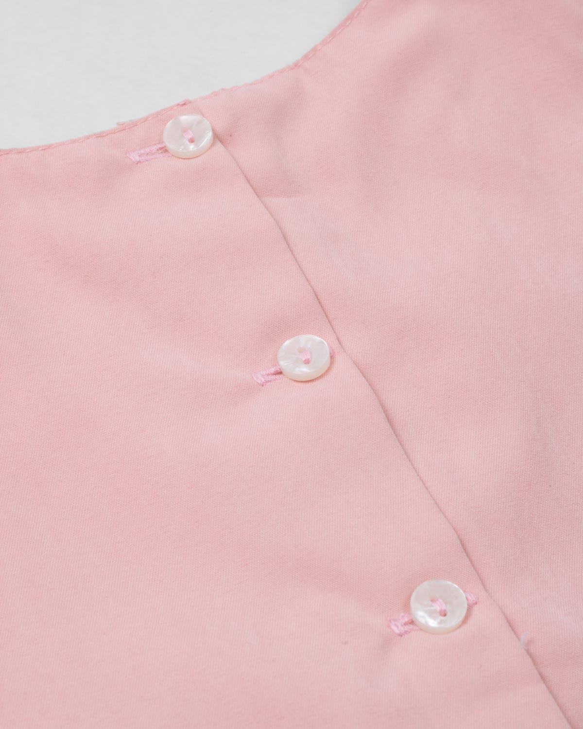 Conjunto blusa rosa pastel con moñito estampado, botonadura en espalda y short azul para bebé niña