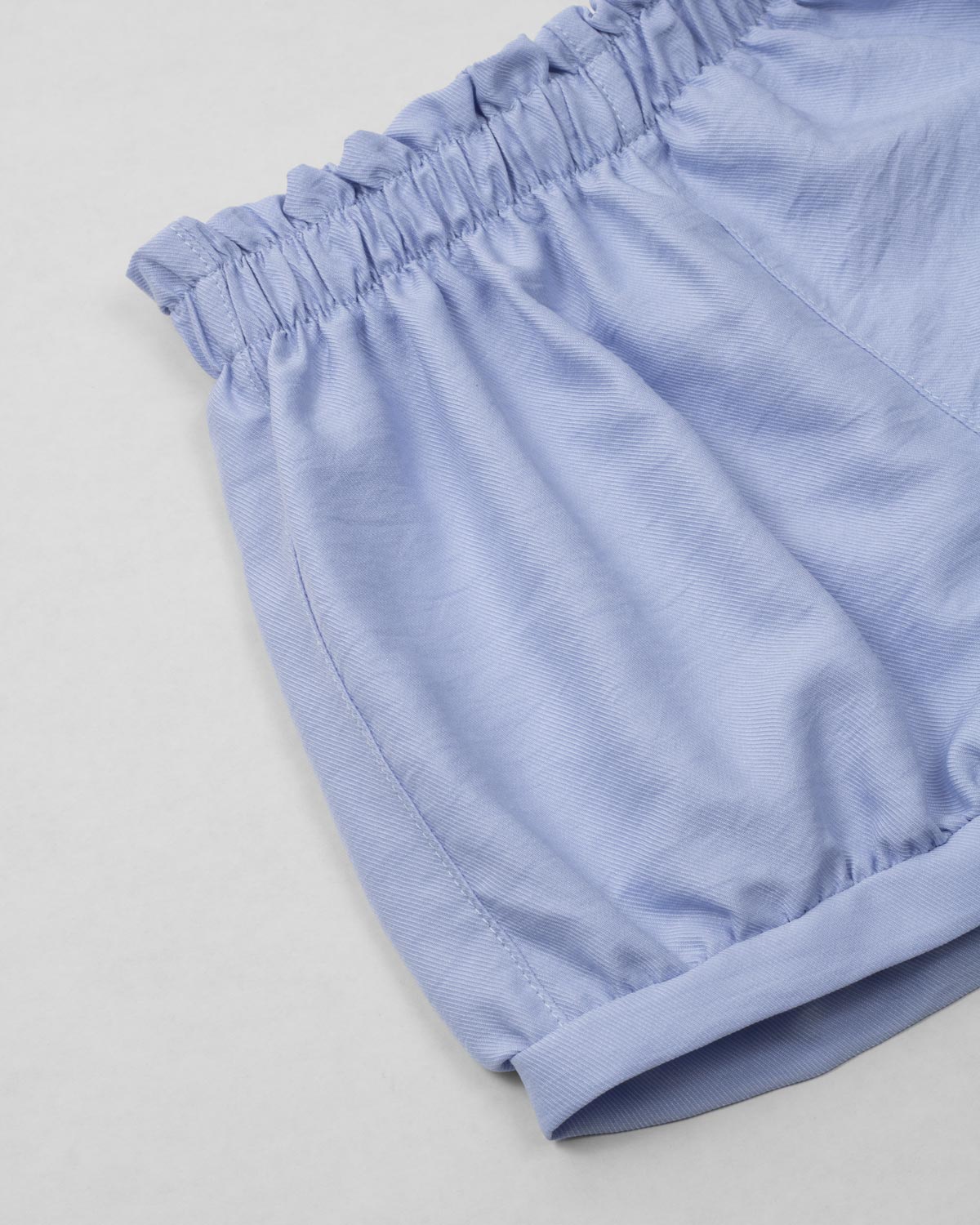 Conjunto blusa rosa pastel con moñito estampado, botonadura en espalda y short azul para bebé niña