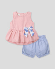 Conjunto blusa rosa pastel con moñito estampado, botonadura en espalda y short azul para bebé niña
