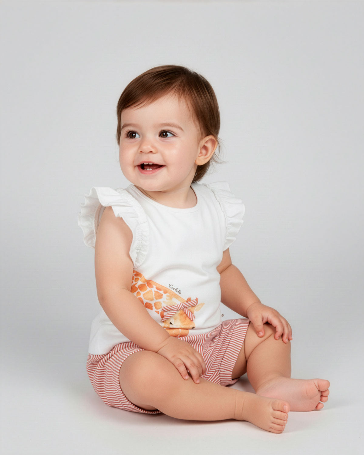 Conjunto blusa blanca con estampado de jirafas y short de líneas naranja para bebé niña