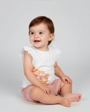 Conjunto blusa blanca con estampado de jirafas y short de líneas naranja para bebé niña