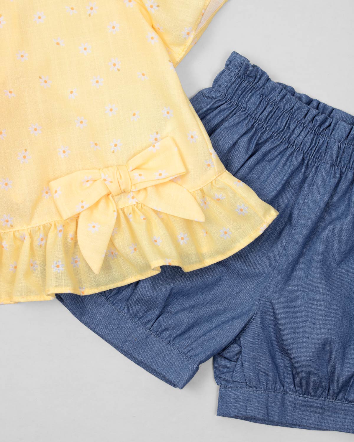 Conjunto blusa amarilla con estampado de flores, moño y short azul para bebé niña