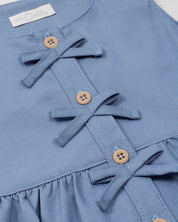 Conjunto blusa azul con moñitos y short rosa con estampado para bebé niña