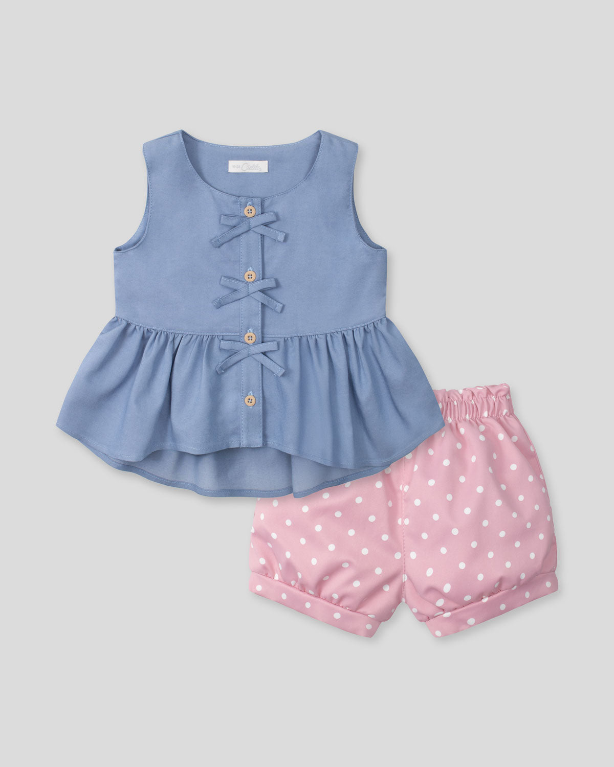 Conjunto blusa azul con moñitos y short rosa con estampado para bebé niña