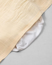 Vestido body en lino blanco y amarillo con detalle de moño para bebé niña