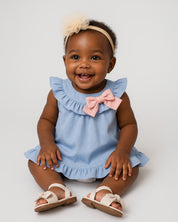 Vestido body azul con boleros y moñito rosa para bebé niña