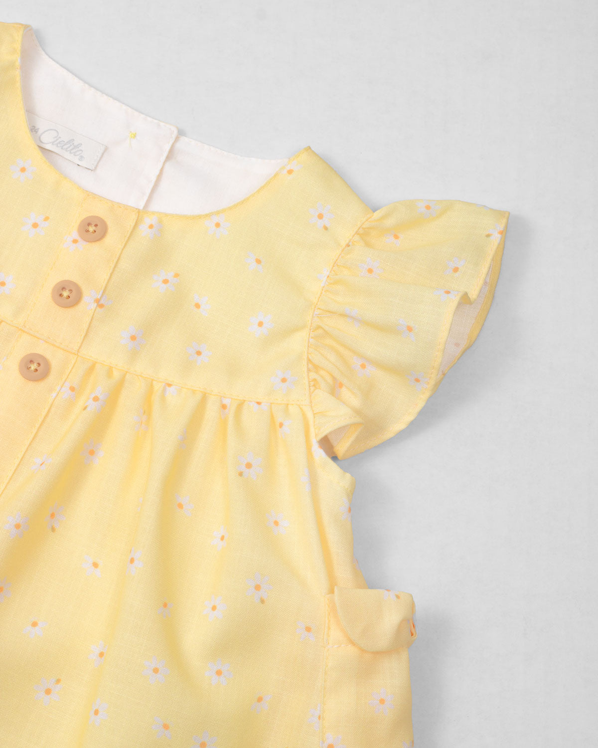 Vestido body amarillo con estampado de flores y bolsillitos en los costados para bebé niña