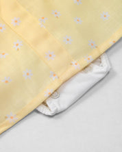 Vestido body amarillo con estampado de flores y bolsillitos en los costados para bebé niña