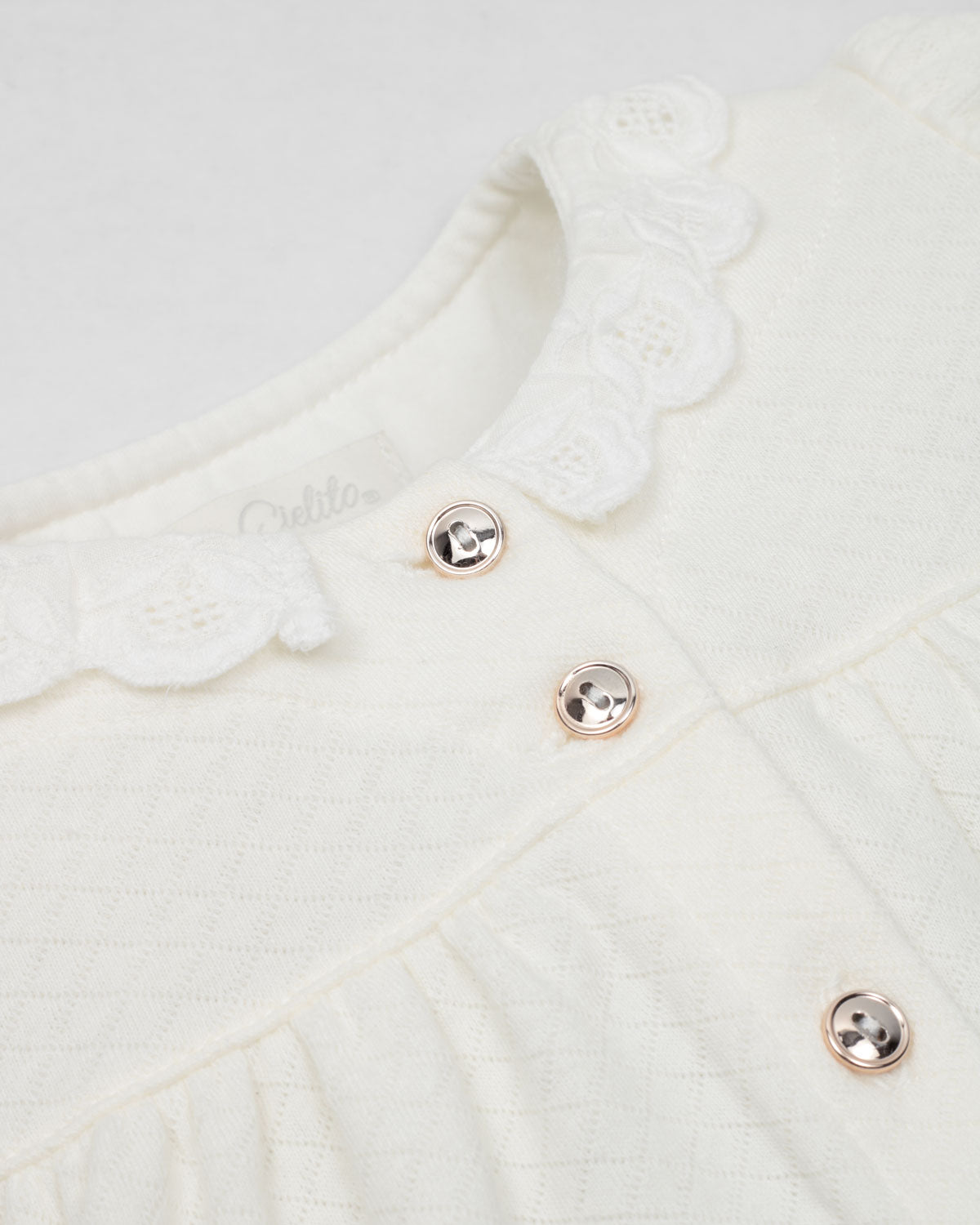 Pijamas enteriza blanca crema con botones y corazones en los costados para bebé niña