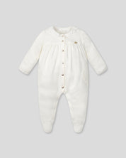 Pijamas enteriza blanca crema con botones y corazones en los costados para bebé niña