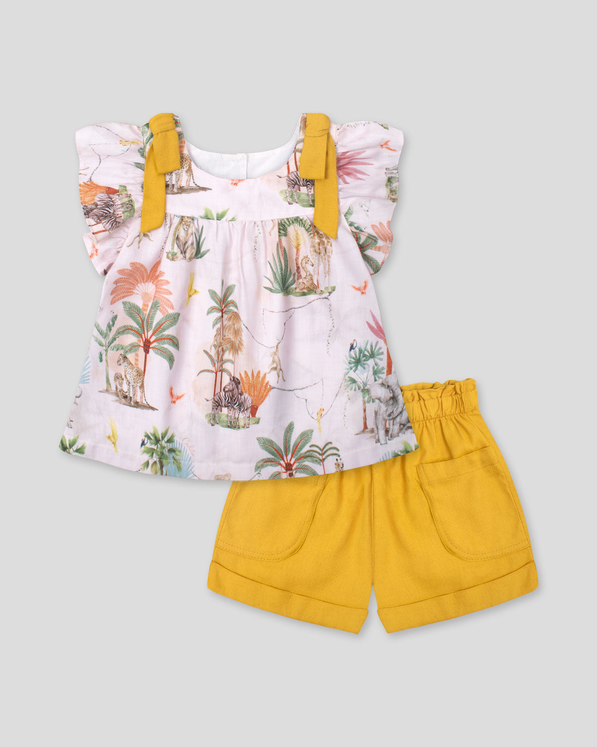 Conjunto blusa estampada con detalle de moños en hombros y short mostaza para niña