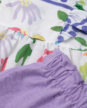 Conjunto blusa estampada de mangas con boleros, moño en espalda y short lila en para niña