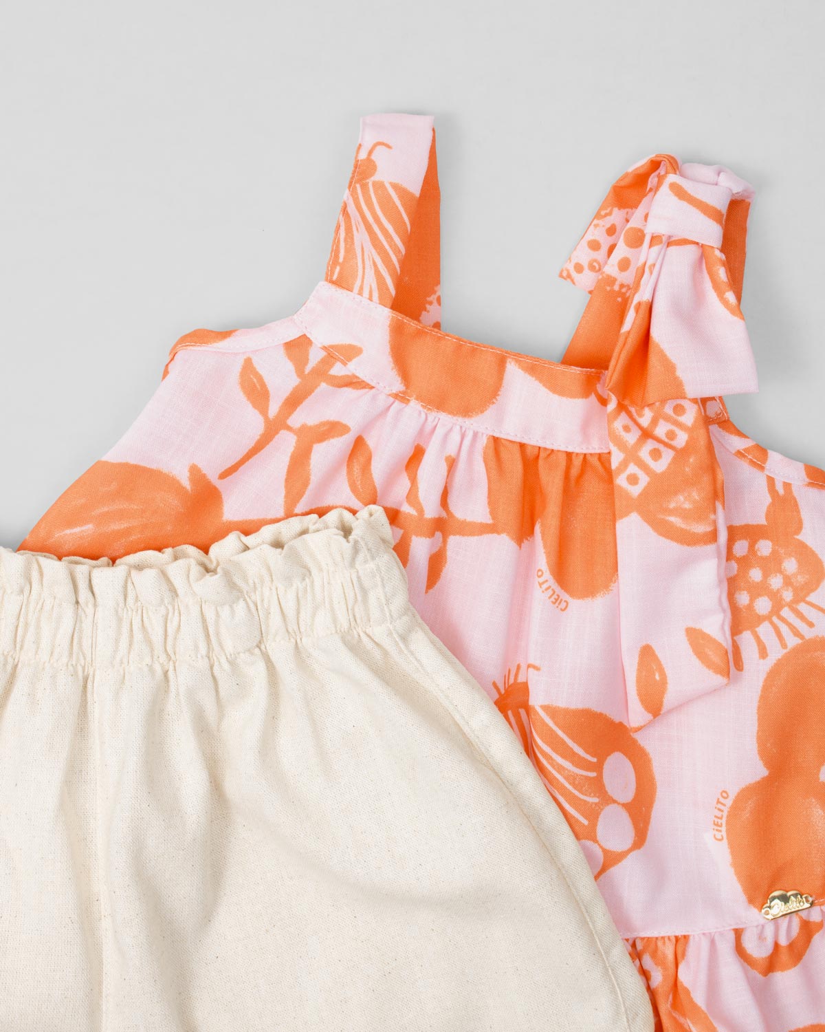 Conjunto blusa estampada de tiras con detalle de moño y short beige para niña