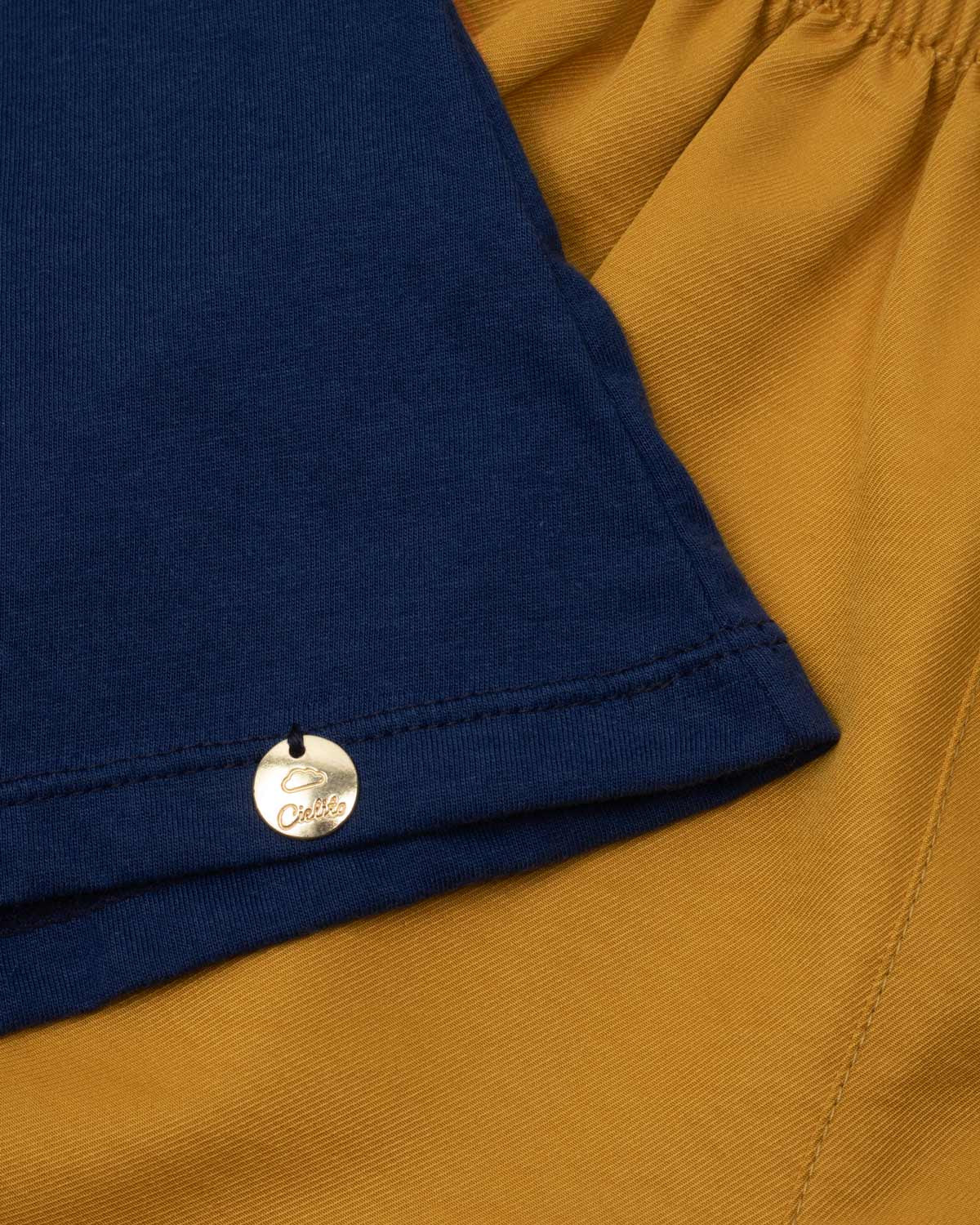 Conjunto blusa azul con estampado y short mostaza para niña