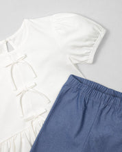 Conjunto blusa blanca con detalle de moñitos, terminado en bolero y leggins azul para niña