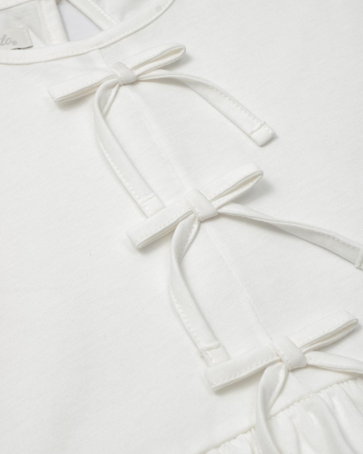 Conjunto blusa blanca con detalle de moñitos, terminado en bolero y leggins azul para niña