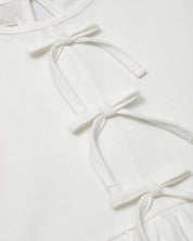 Conjunto blusa blanca con detalle de moñitos, terminado en bolero y leggins azul para niña