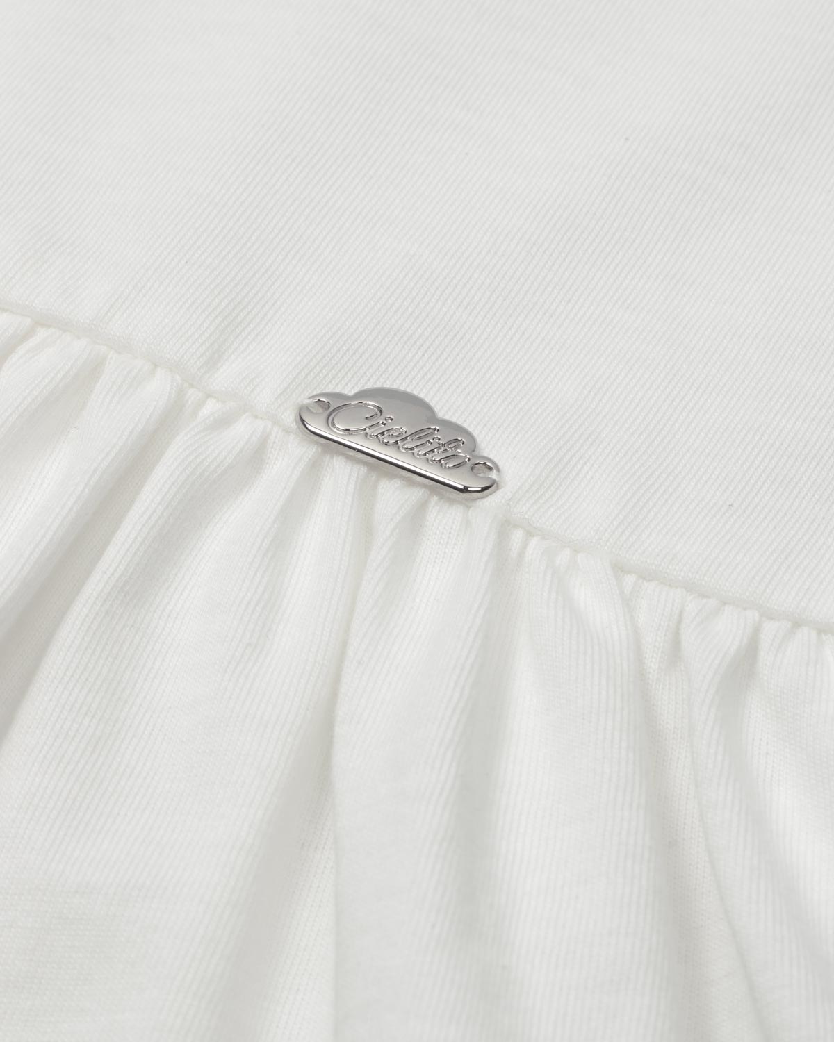 Conjunto blusa blanca con detalle de moñitos, terminado en bolero y leggins azul para niña