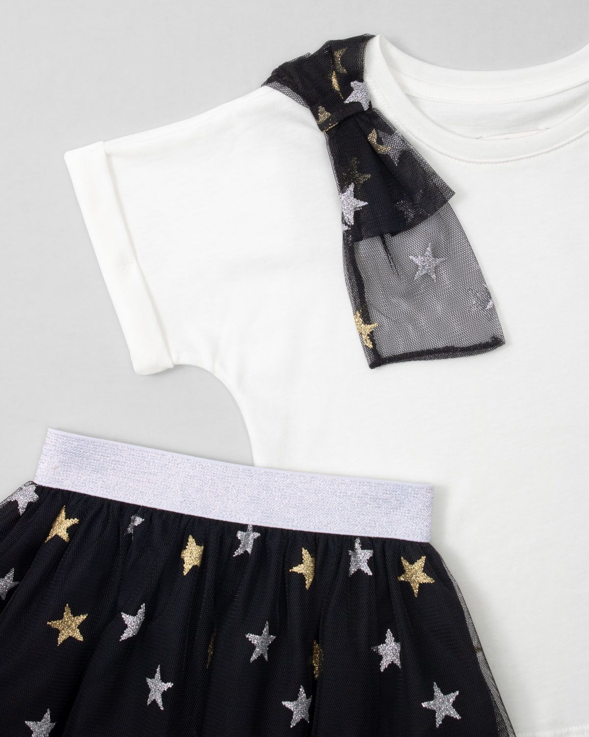 Conjunto camiseta blanca con moño y falda negra en tul con estrellas para niña