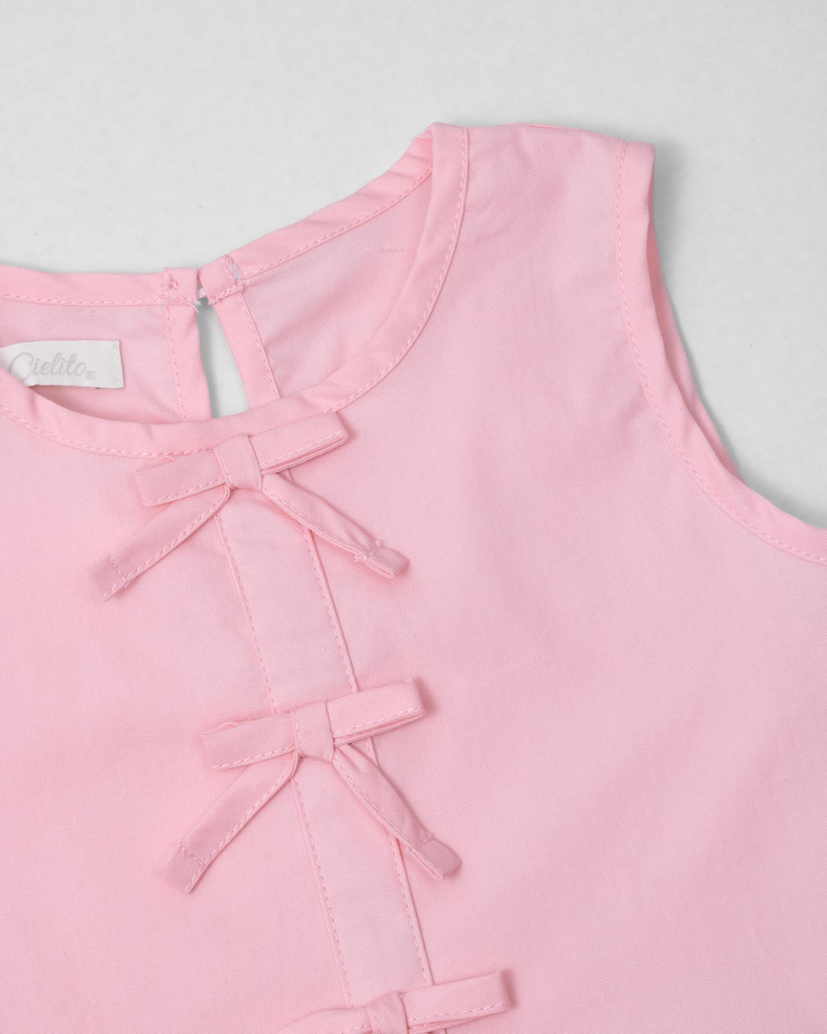 Blusa rosa con detalle de moñitos y bolero para niña