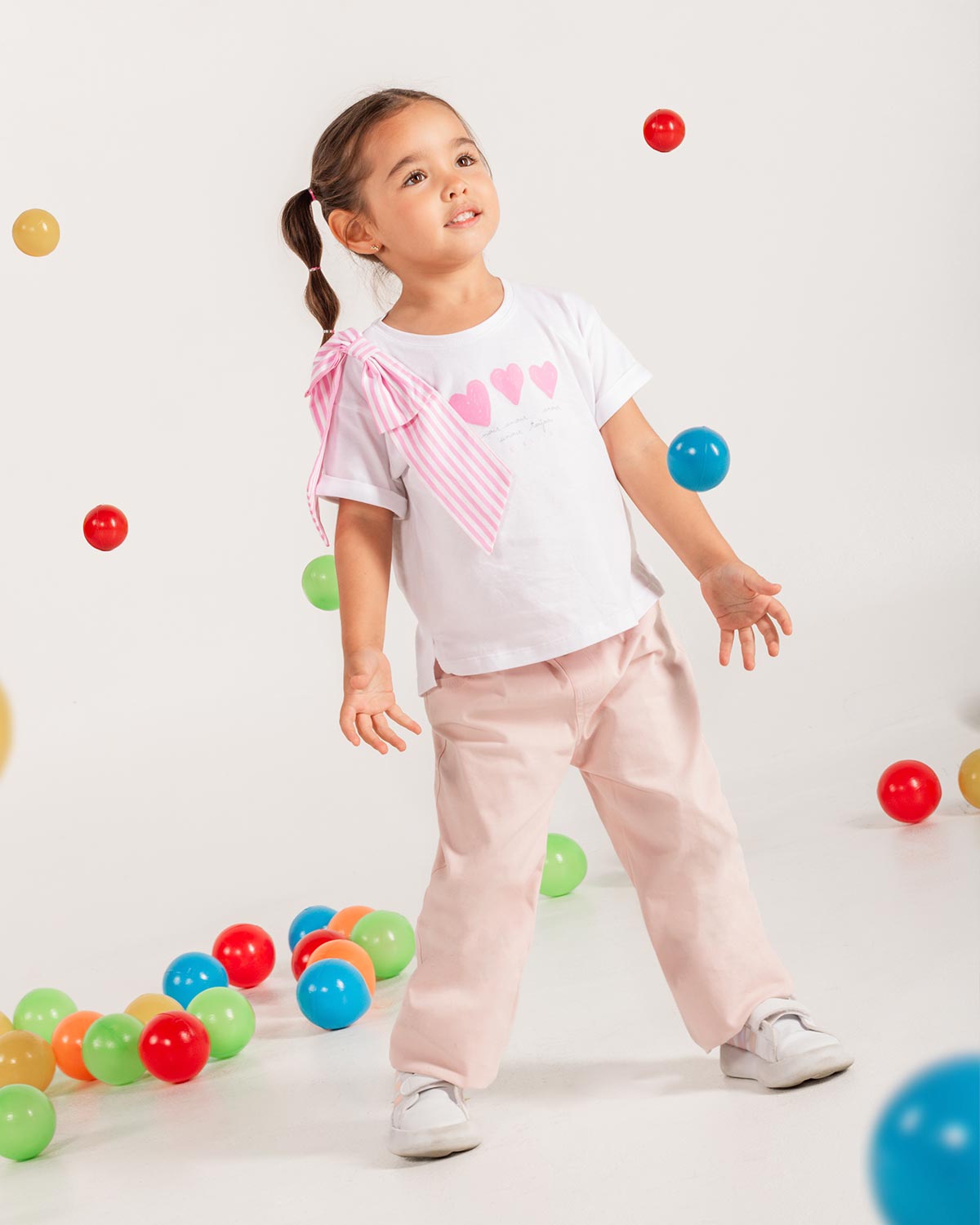 Camiseta blanca con estampado de corazones y moño en hombro de rayas rosa para niña