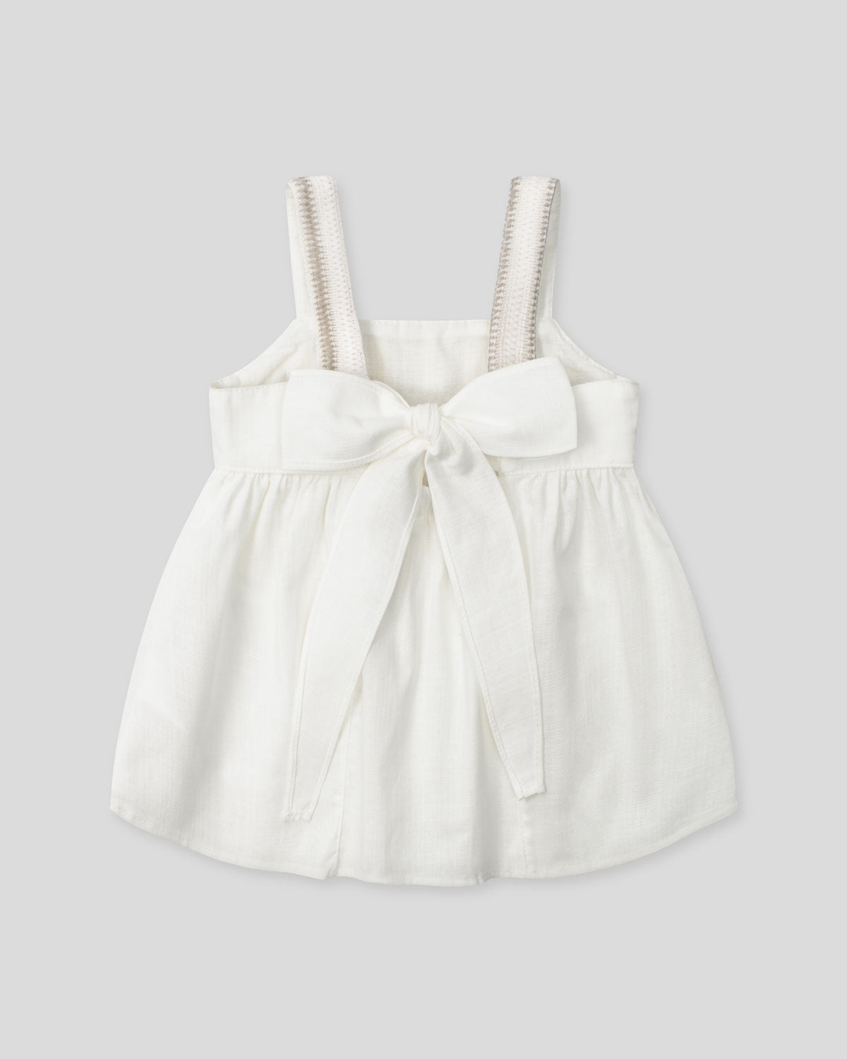 Blusa en lino con textura tejida y moño en espalda para niña