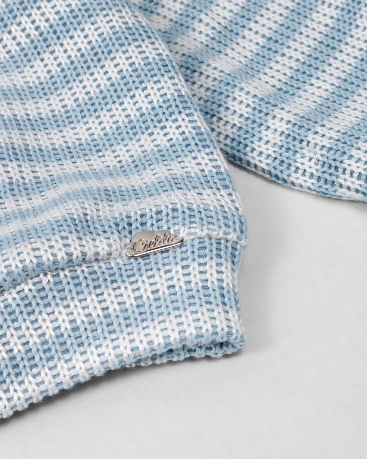 Saco en tela tejita blanco y azul con moño rosado para niña