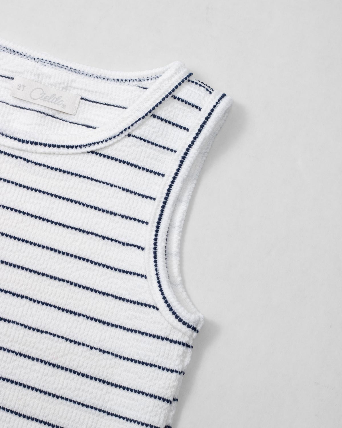 Blusa manga sisa blanca con líneas y moño rosa en hombro para niña
