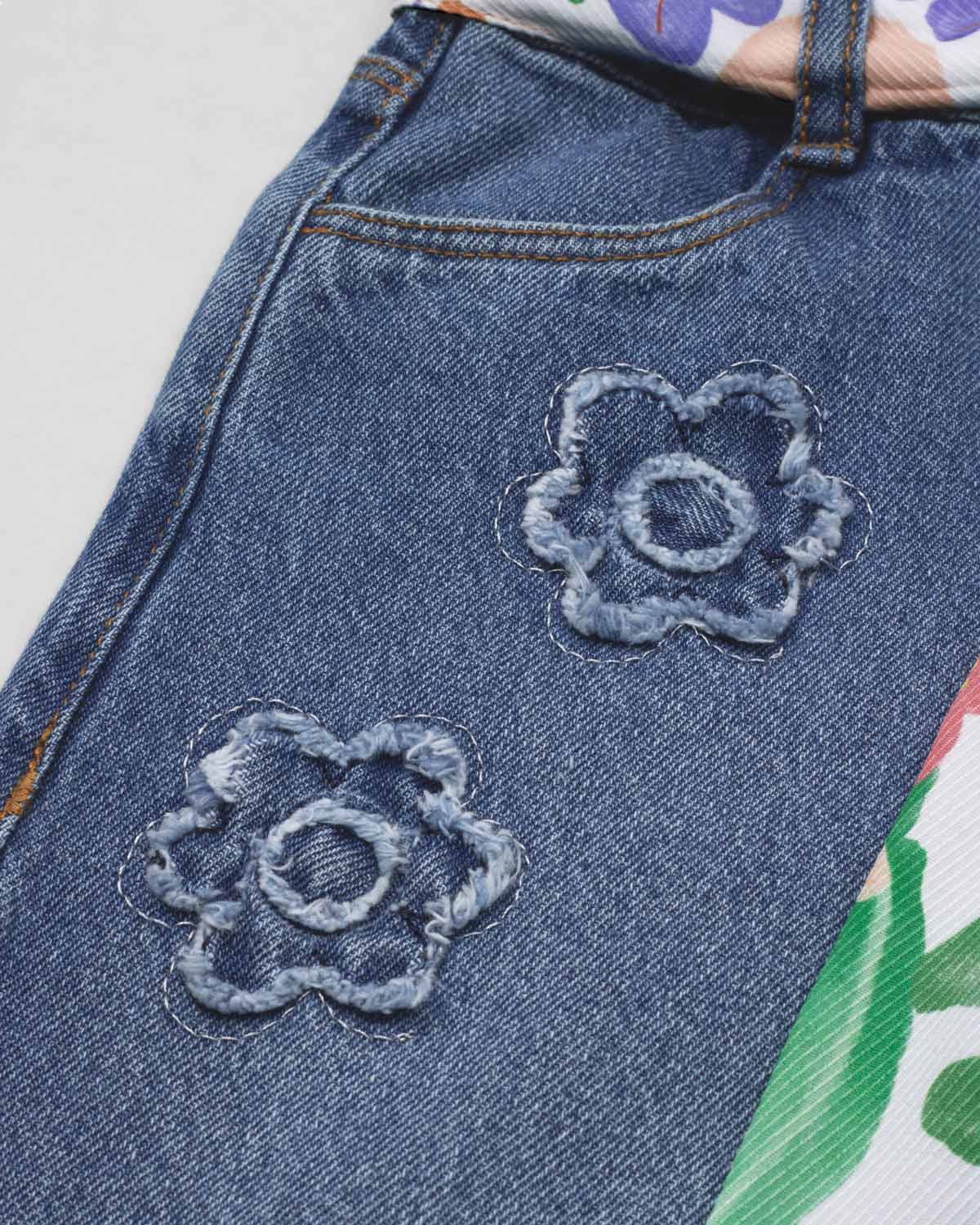 Jean denim marine fit con cinturón estampado y flores bordadas para niña