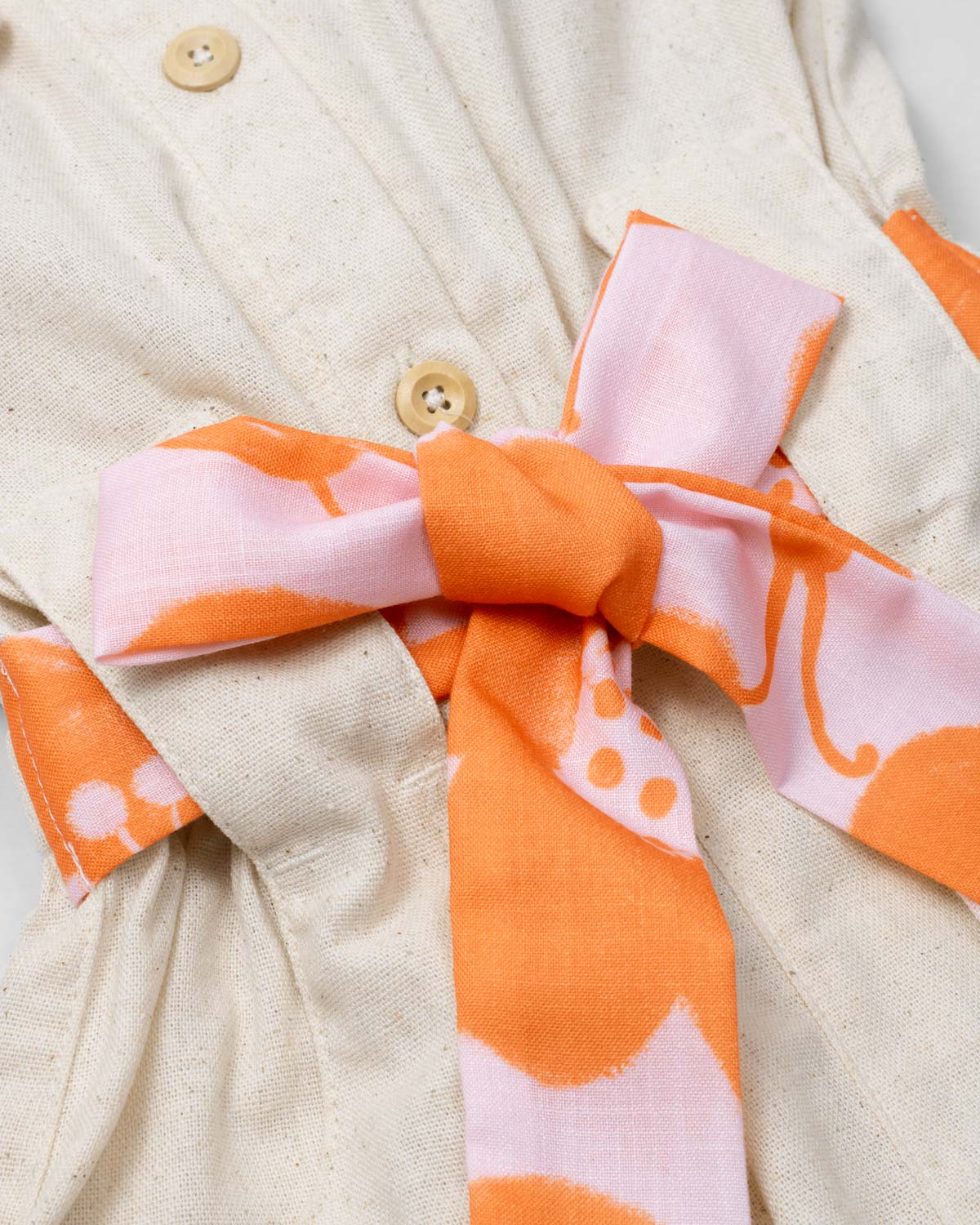 Enterizo en lino con botonadura y cinturón estampado para niña