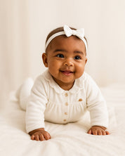 Pijamas enteriza blanca crema con botones y corazones en los costados para bebé niña