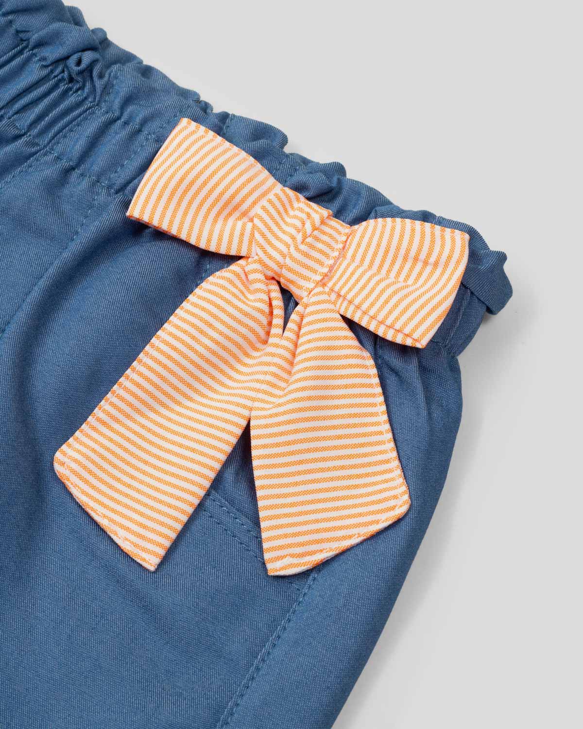 Conjunto blusa de líneas naranjas con bolero en manga y leggins chambray con detalle de moño para bebé niña