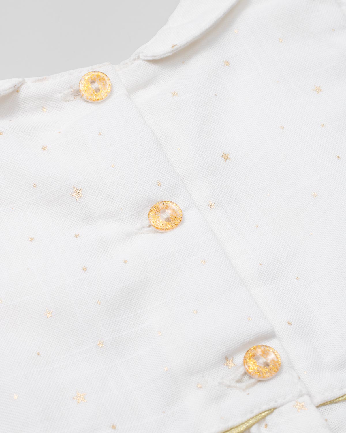 Conjunto blusa blanca en lino con estrellitas doradas, botonadura en espalda y short dorado para bebé niña