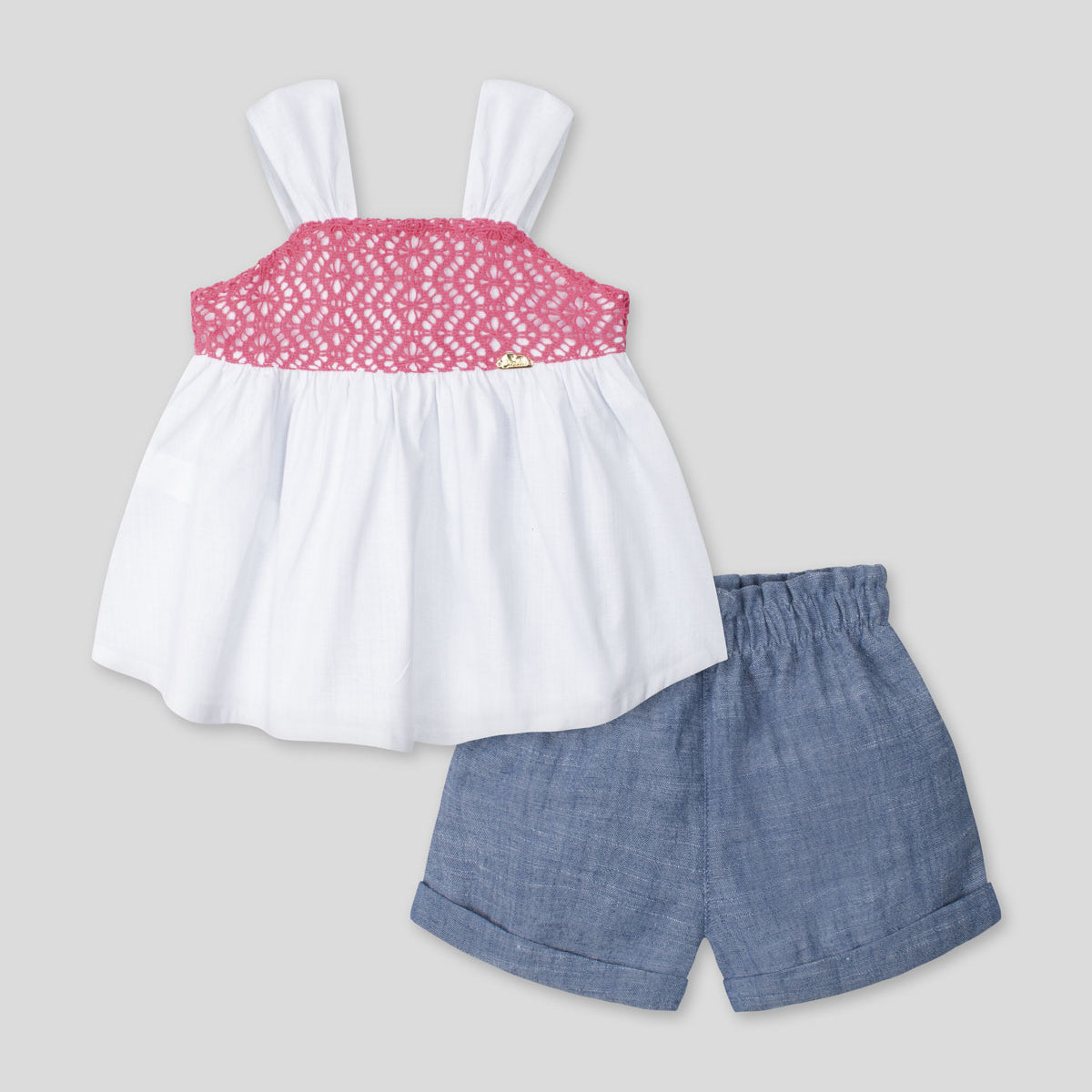 Conjunto blusa blanca de tiras con textura tejida, moño en espalda y short azul para bebé niña
