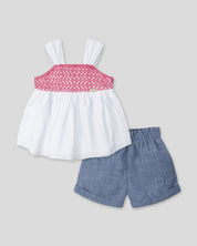 Conjunto blusa blanca de tiras con textura tejida, moño en espalda y short azul para bebé niña