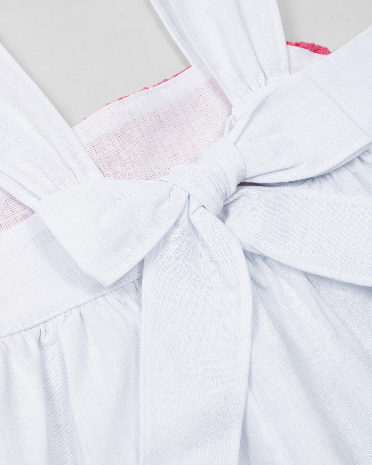 Conjunto blusa blanca de tiras con textura tejida, moño en espalda y short azul para bebé niña