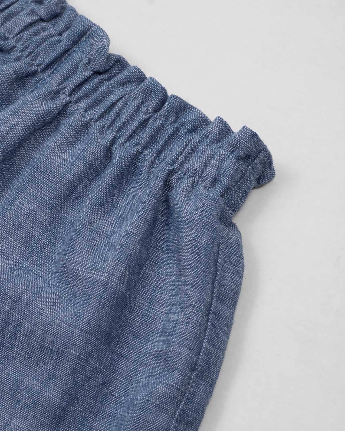 Conjunto blusa blanca de tiras con textura tejida, moño en espalda y short azul para bebé niña