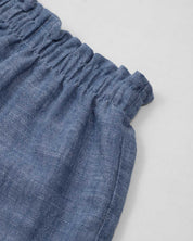 Conjunto blusa blanca de tiras con textura tejida, moño en espalda y short azul para bebé niña