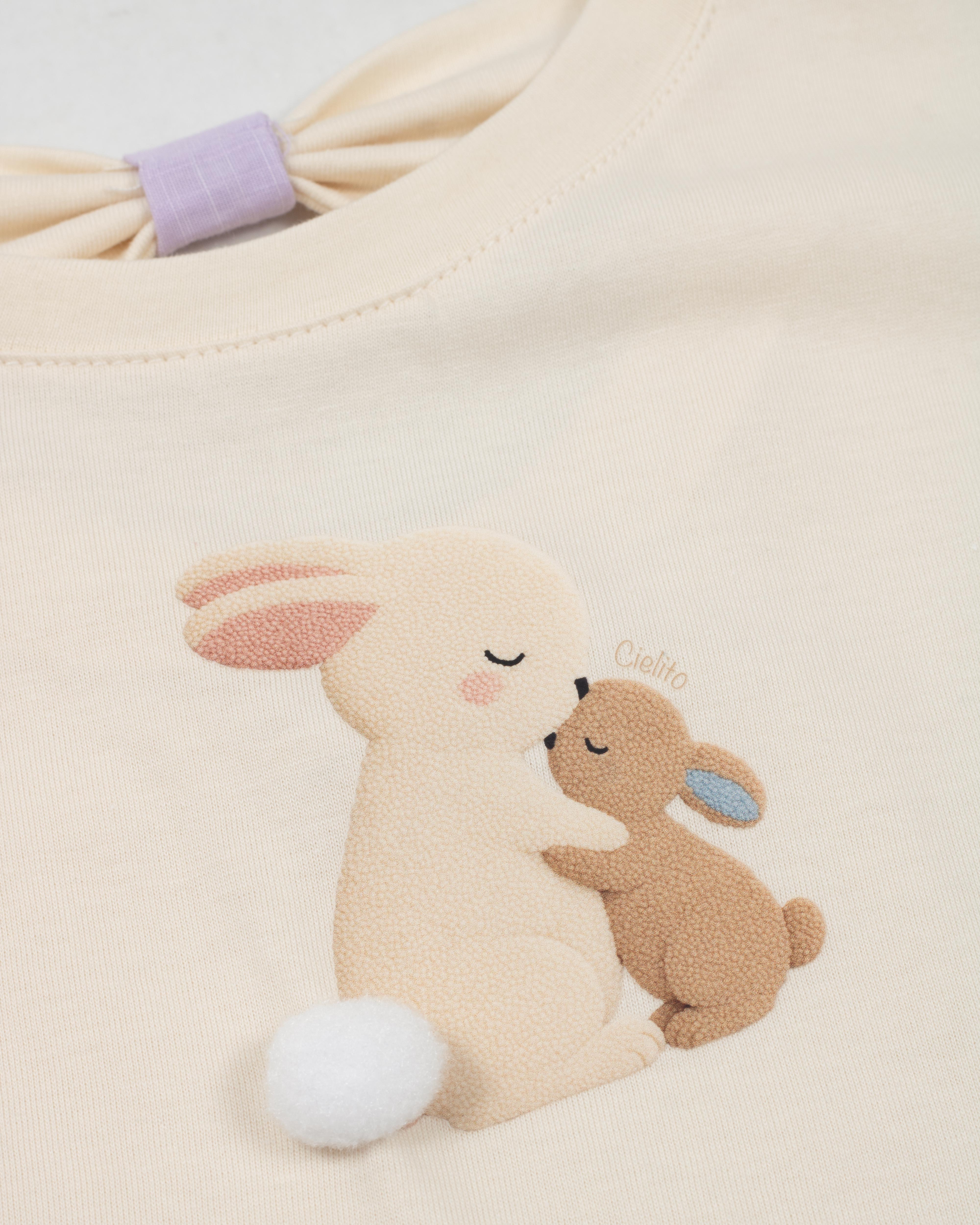 Conjunto blusa crema con estampado de conejitos y short lila para bebé niña