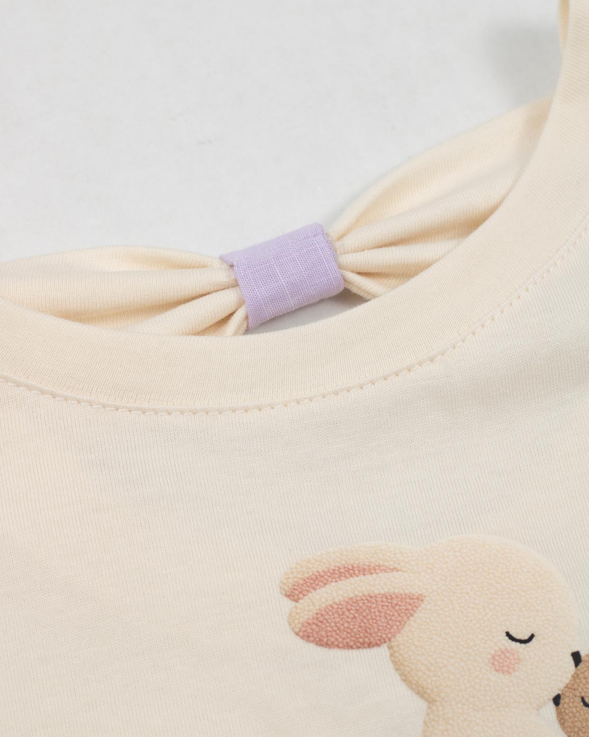 Conjunto blusa crema con estampado de conejitos y short lila para bebé niña