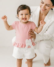 Conjunto blusa palo de rosa con moño y short blanco para bebé
