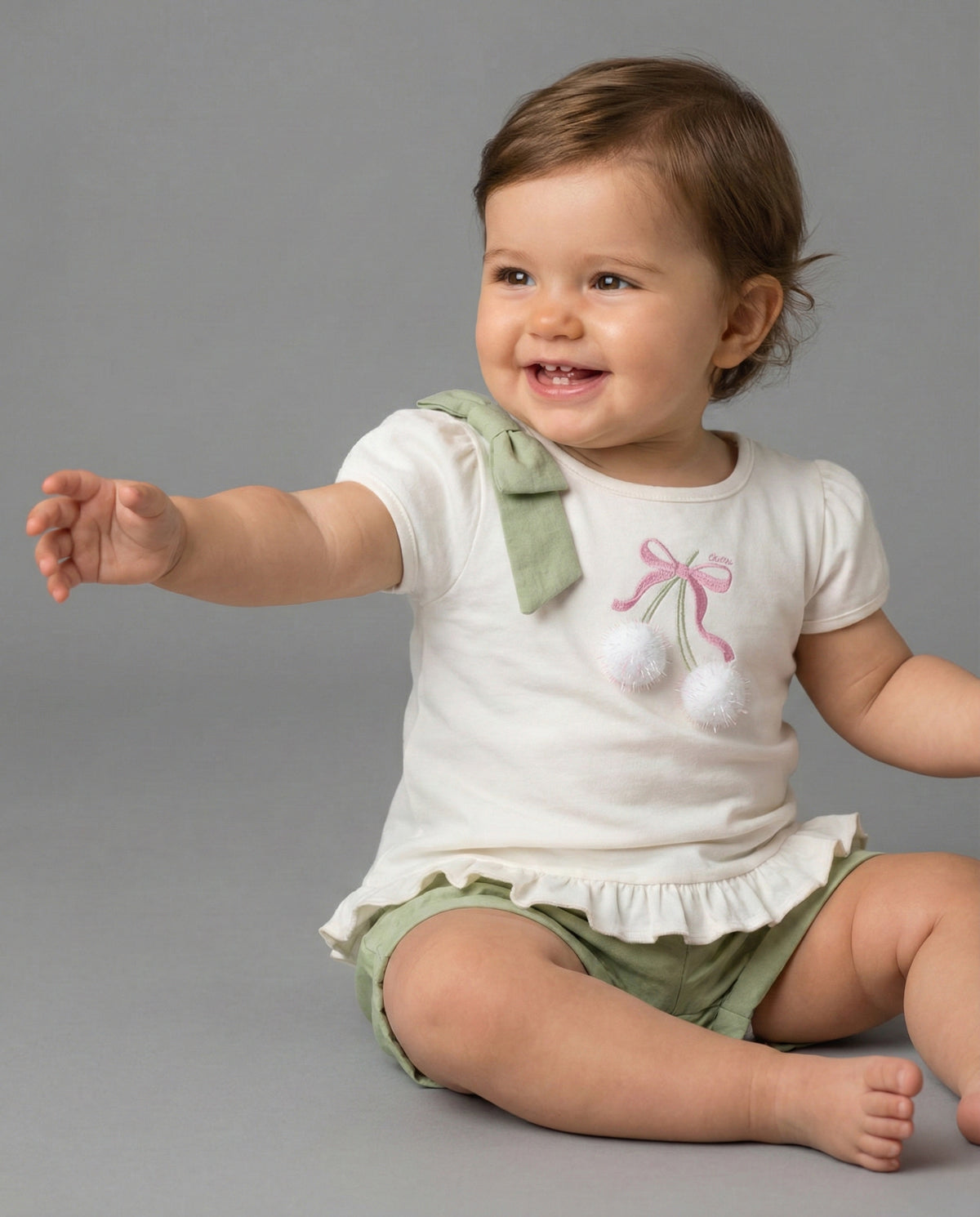 Conjunto blusa blanca con estampado, moño y short verde para niña