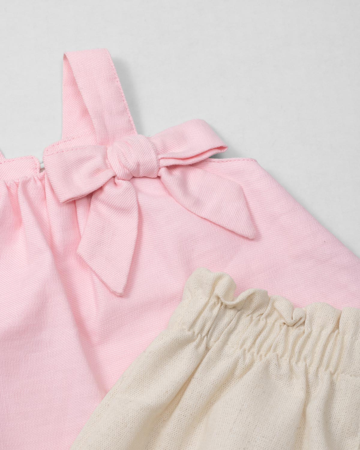 Conjunto blusa de tiras con moño rosa y short beige para bebé niña