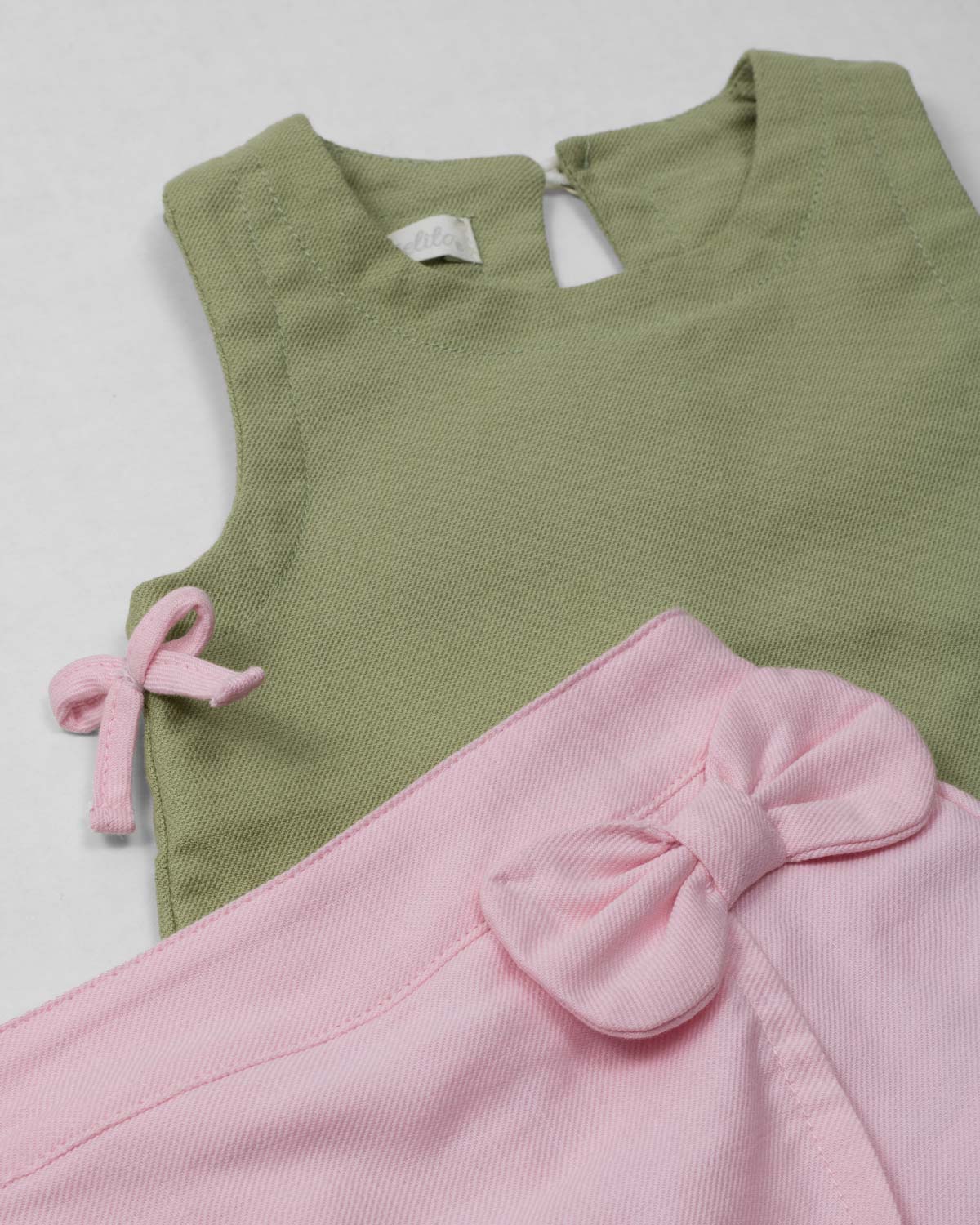 Conjunto blusa manga sisa verde con moñitos y  short rosa para bebé niña