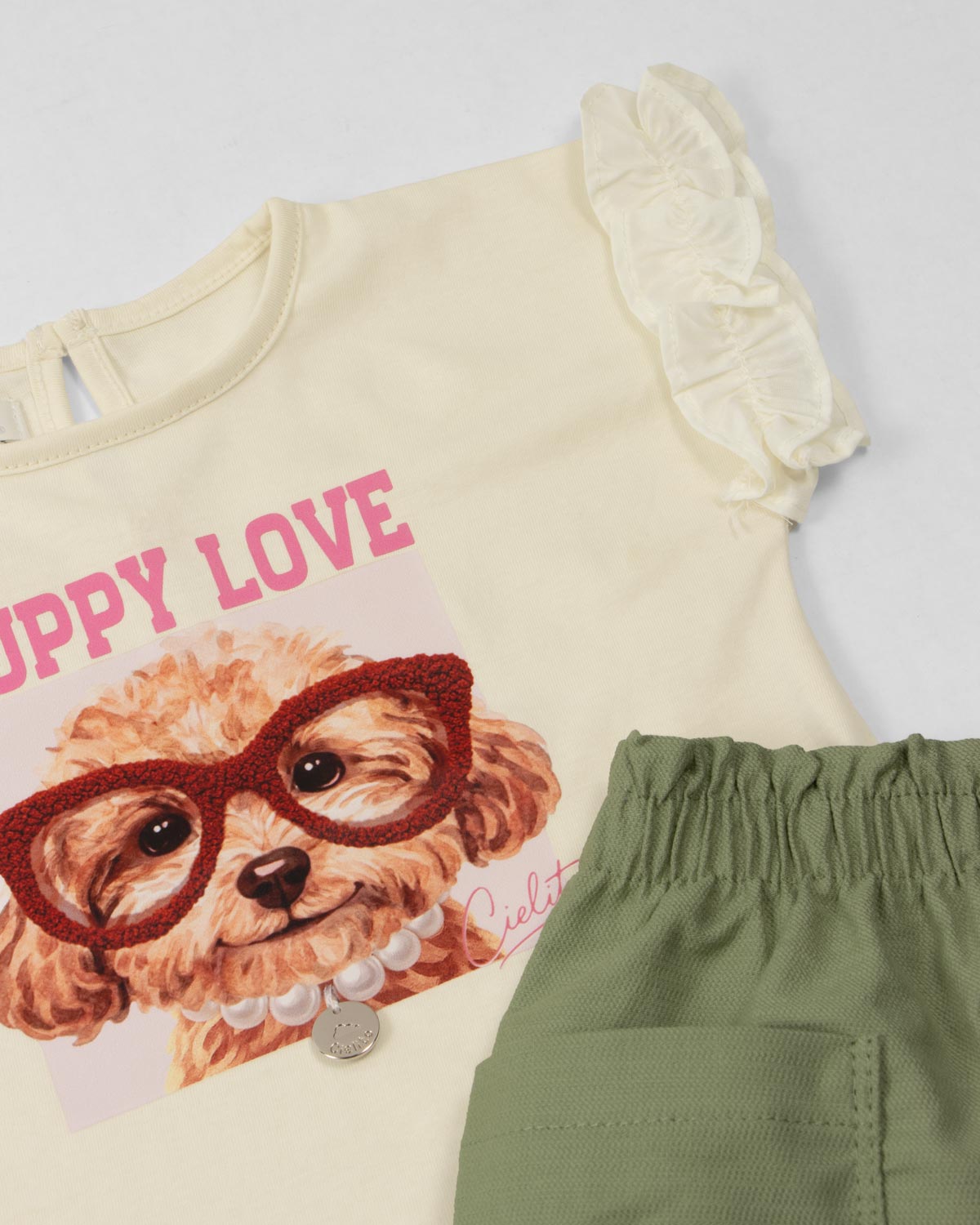 Conjunto camiseta crema con estampado y short verde con bolsillos para bebé niña