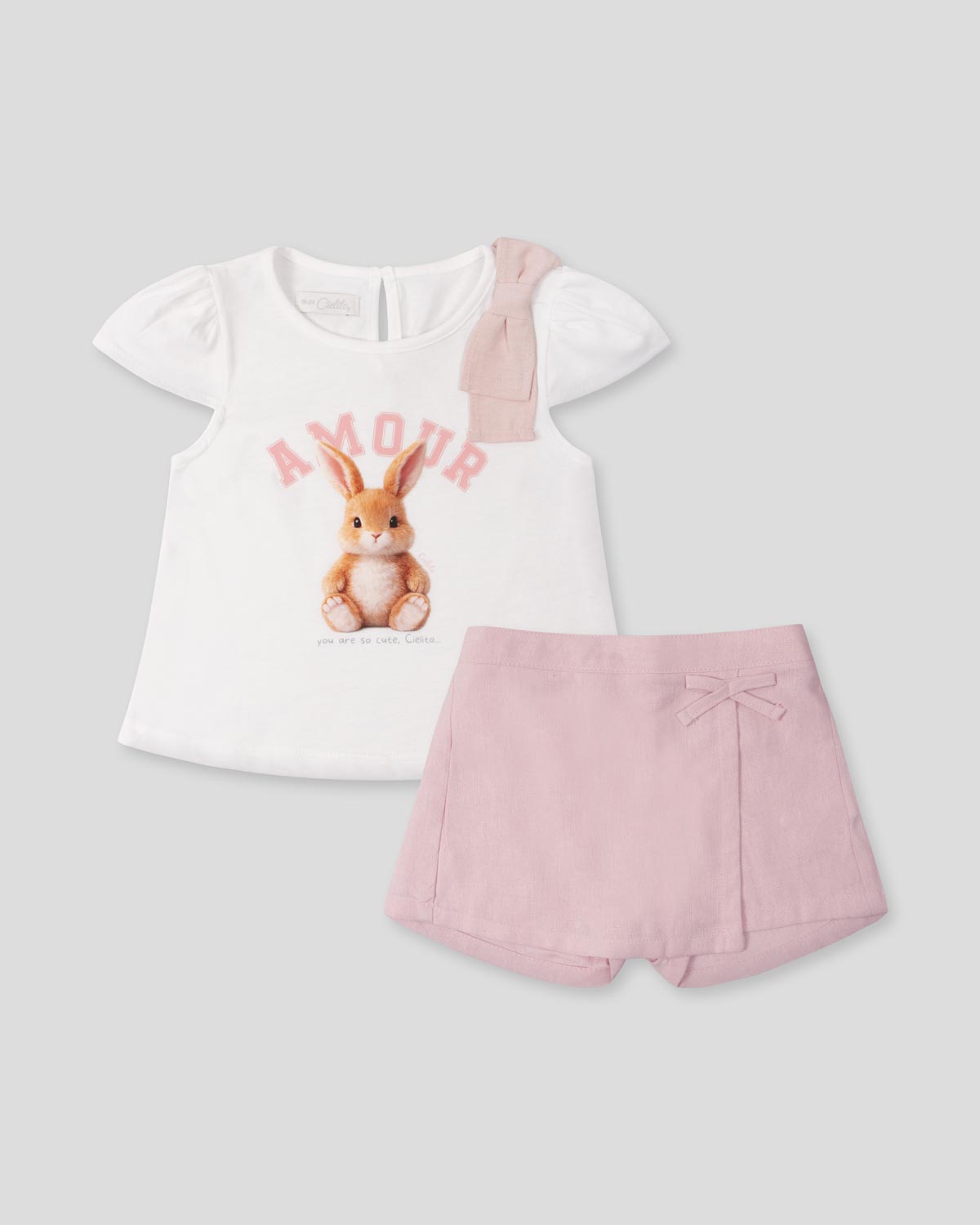 Conjunto blusa blanca estampada con moñito en hombro y falda short rosa para bebé niña