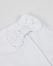 Conjunto blusa rosa con moño en tela hoja rota y falda short blanca para bebé niña