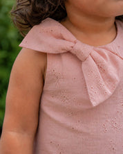 Conjunto blusa rosa con moño en tela hoja rota y falda short blanca para bebé niña