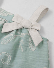 Conjunto blusa verde menta en tela bordada con moño y falda short beige para bebé niña