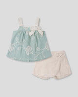 Conjunto blusa verde menta en tela bordada con moño y falda short beige para bebé niña